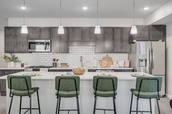 A kitchen with a white countertop and green barstools.